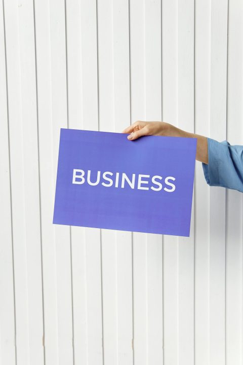 A hand holds a blue placard with 